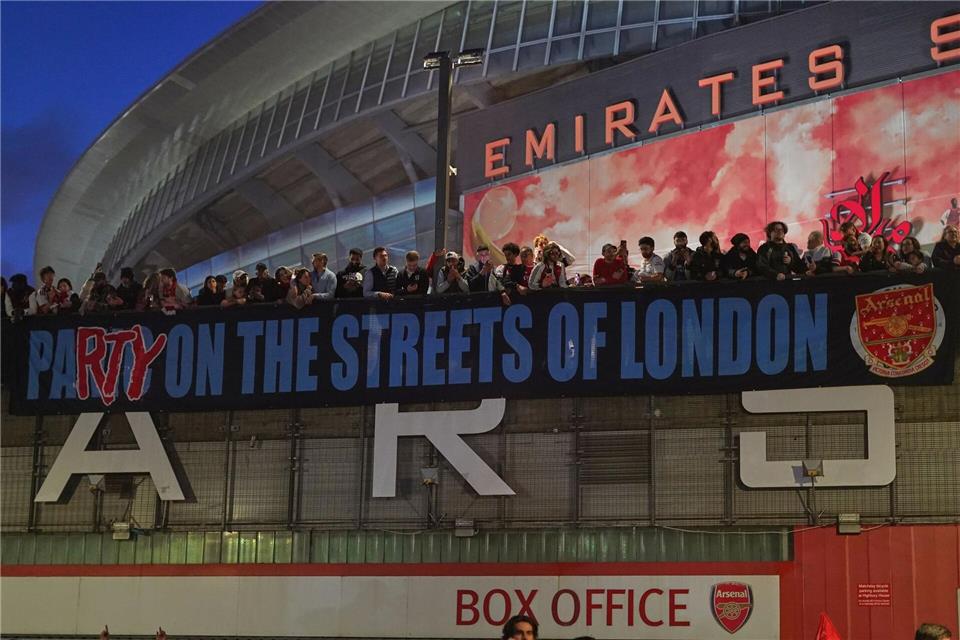 Arsenal-Fans zeigen nach dem Titelgewinn ein Banner am Stadion: „Party auf Londons Straßen“Alberto Pezzali/AP/dpa
