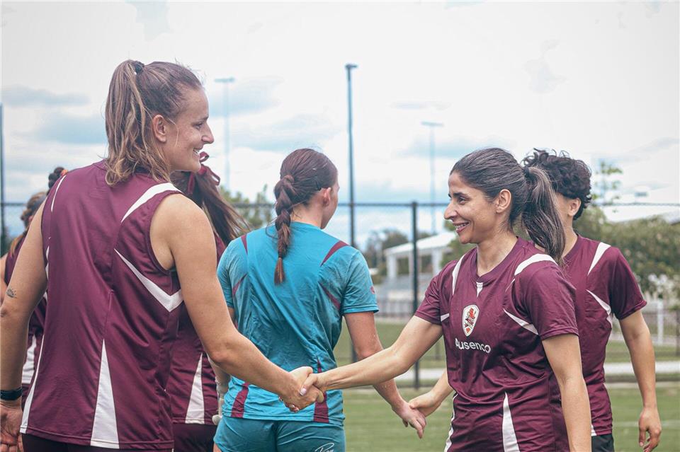 Atefeh Ramezanisadeh (r) wird von einer Mitspielerin begrüßt.Brisbane Roar/Brisbane Roar/AP/dpa