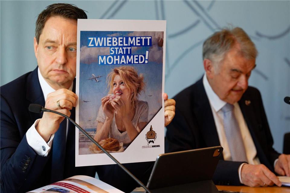 Auch Rechtsextremisten sind mit fremdenfeindlichen Parolen aktiv, wie Jürgen Kayser (links) als Leiter des Verfassungsschutzes Nordrhein-Westfalen zeigt. Henning Kaiser/dpa