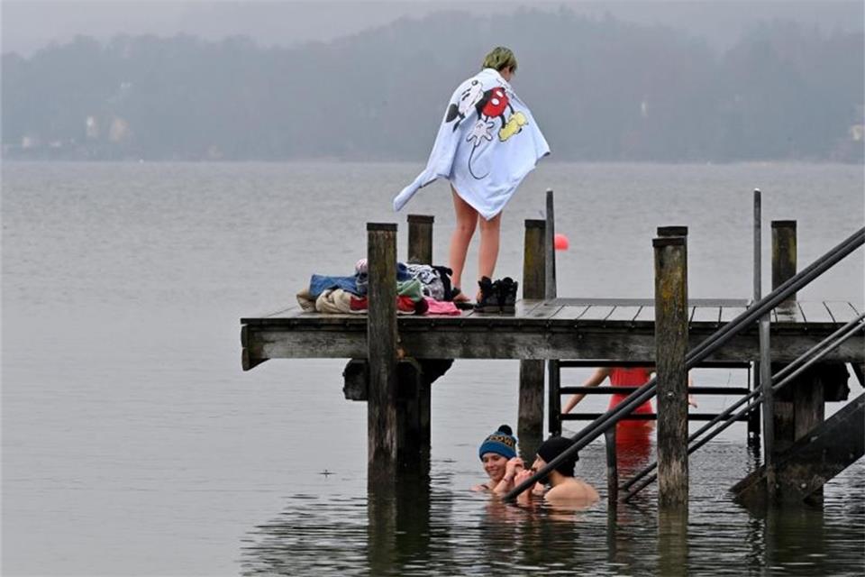 Lockdown-Trend Eisbaden: Heilsversprechen oder Risiko? Auch am Starnberger See in Bayern wird bei eisigen Temperaturen gebadet - mit Pudelmützen. Foto: Peter Kneffel/dpa