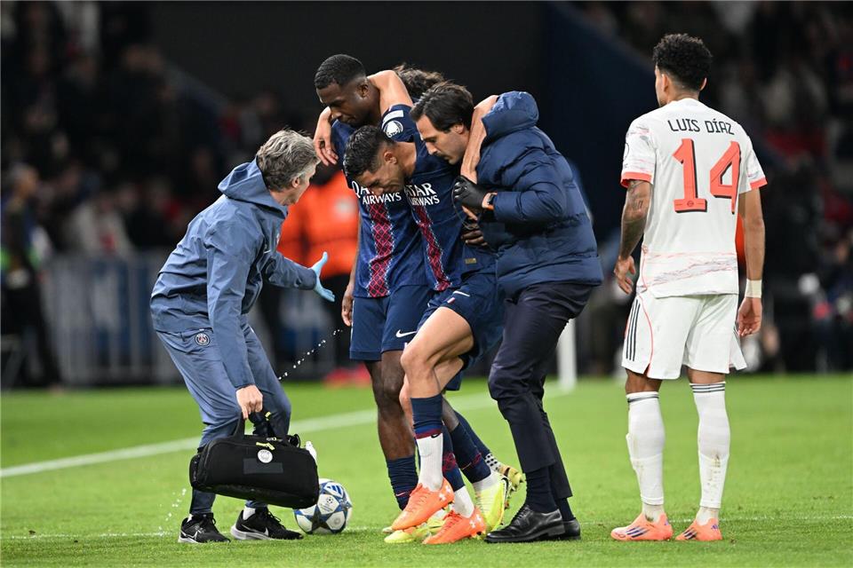 Auf Betreuer gestützt wird der am Fuß verletzte PSG-Spieler Achraf Hakimi (M) vom Platz geführt. Federico Gambarini/dpa