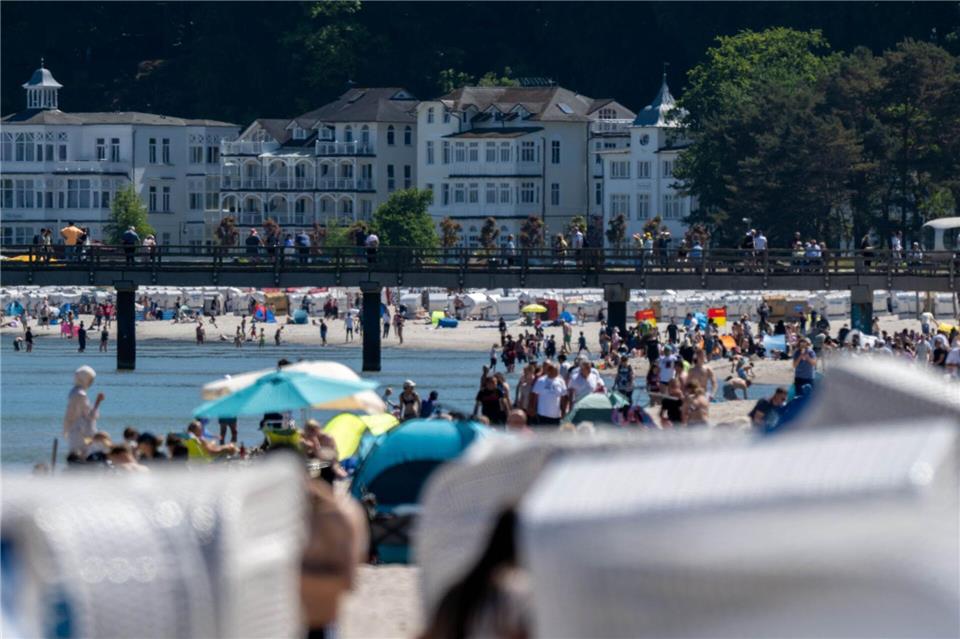 Auf Binz ist der Strand gefüllt, vereinzelt sind auch Menschen im Wasser. (Archivbild.) Stefan Sauer/dpa