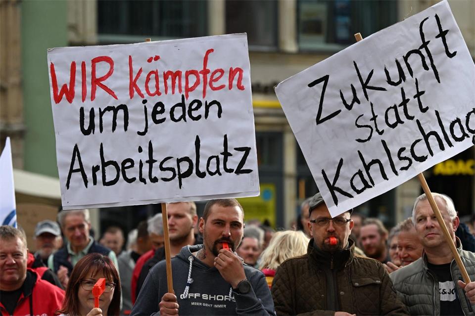 Auf Plakaten machen Teilnehmer der Kundgebung in Zwickau ihrem Unmut über weiteren Jobabbau in der Automobilbranche Luft. Hendrik Schmidt/dpa