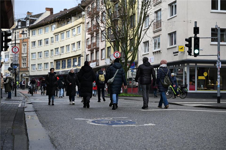 Auf abgesperrten Straßen gehen Passanten durch die Innenstadt von Gießen. Michael Brandt/dpa