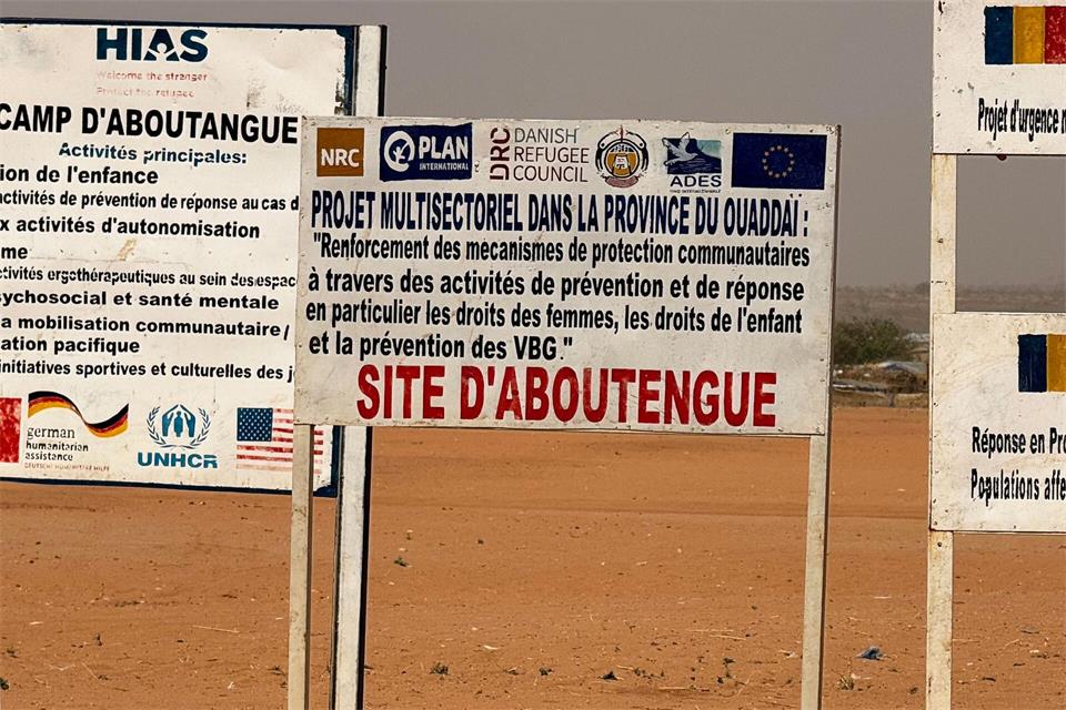 Auf dem Gelände eines Lagers für Flüchtlinge aus dem Sudan im Osten des Tschads stehen die Logos von Hilfsorganisationen, die dort im Einsatz sind. (Archivbild)Eva Krafczyk/dpa