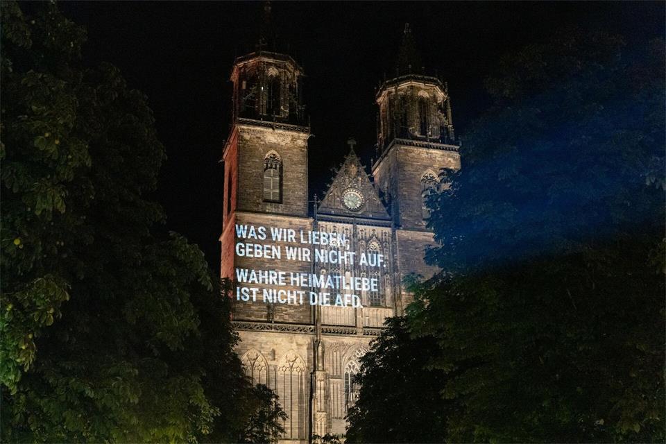 Auf dem Magdeburger Dom war zu lesen: „Was wir lieben, geben wir nicht auf. Wahre Heimatliebe ist nicht die AfD.“ -/Mehr als uns trennt e.V./dpa