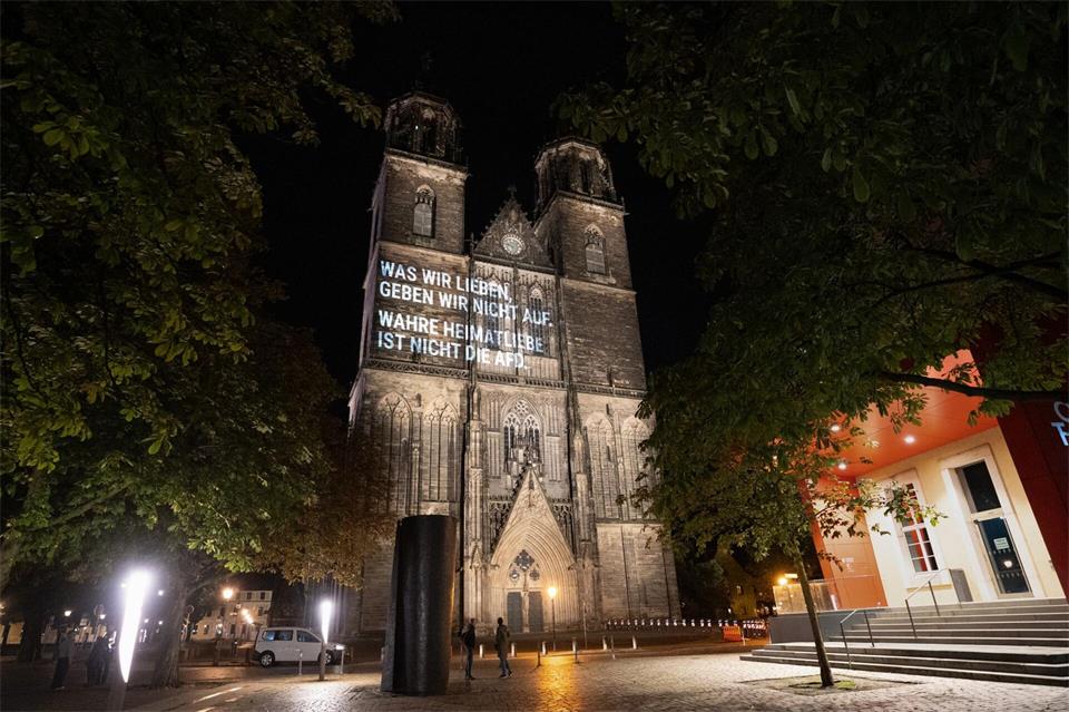 Auf dem Magdeburger Dom war zu lesen: „Was wir lieben, geben wir nicht auf. Wahre Heimatliebe ist nicht die AfD.“ -/Mehr als uns trennt e.V./dpa