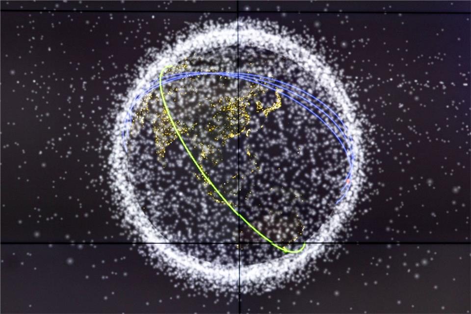 Auf dem Monitor wird die Flugbahn eines ausrangierten Batteriepakets der ISS um die Erde angezeigt.