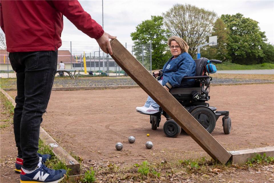 Auf dem umgebauten Sportplatz in Sörgenloch kann auch Rollstuhlnutzerin Gracia Schade Boule spielen. Helmut Fricke/dpa