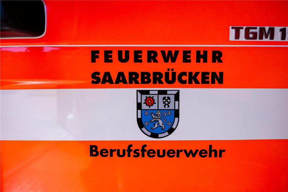 Auf der Fahrzeugtür eines Löschfahrzeugs sind das Saarland-Wappen und der Schriftzug „Feuerwehr Saarbrücken – Berufsfeuerwehr“ zu sehen.Laszlo Pinter/dpa