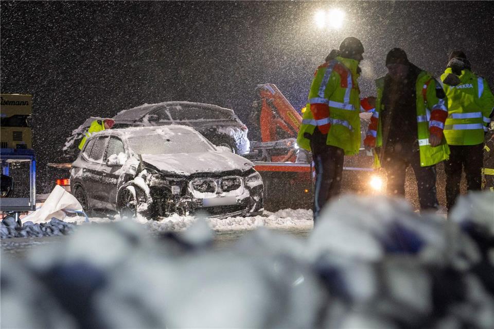 Auf der verschneiten Bundesstraße 12 stehen Feuerwehrmänner an einer Unfallstelle. Stefan Puchner/dpa