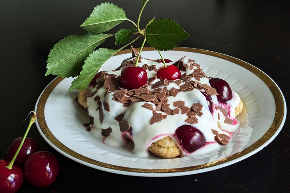 Auf die mit Espresso getränkten Löffelbiskuits kommen eine Quark-Sahne-Masse und reichlich Kirschen. Das Tiramisu wird mit Schokoraspeln getoppt.  Doreen Hassek/hauptstadtkueche.blogspot.com/dpa-tmn