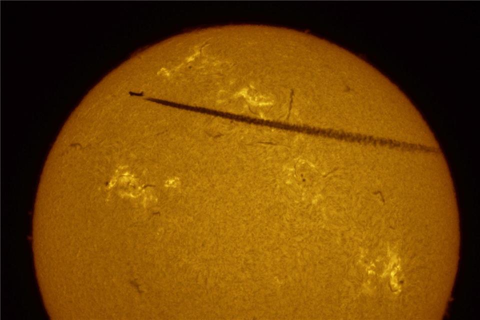 Auf diesem Foto, das mit einem Sonnenteleskop aufgenommen wurde, zeichnet sich ein Verkehrsflugzeug vor der Sonne ab.Dmitri Lovetsky/AP/dpa
