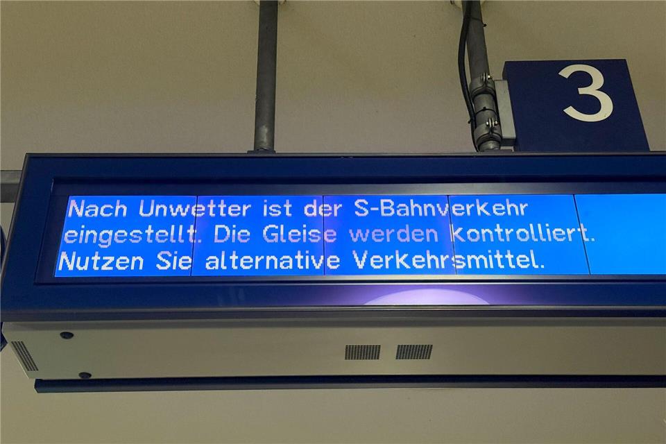 Auf einer Anzeigetafel der Berliner S-Bahn wird auf die Einstellung des S-Bahnverkehrs auf Grund von Unwetter hingewiesen.Paul Zinken/dpa