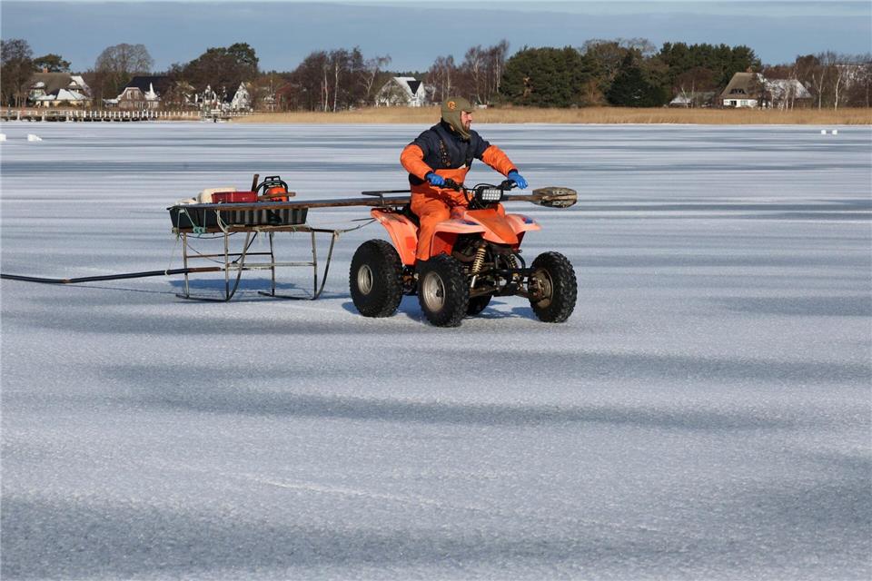 Auf seinem Quad fährt Andy Ahrens über das Eis.Bernd Wüstneck/dpa