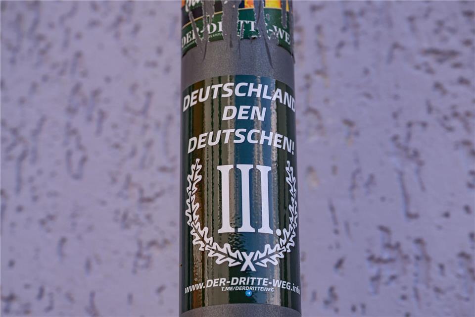 Aufkleber aus der rechtsextremistischen Szene sind an Laternen zu finden. Patrick Pleul/dpa