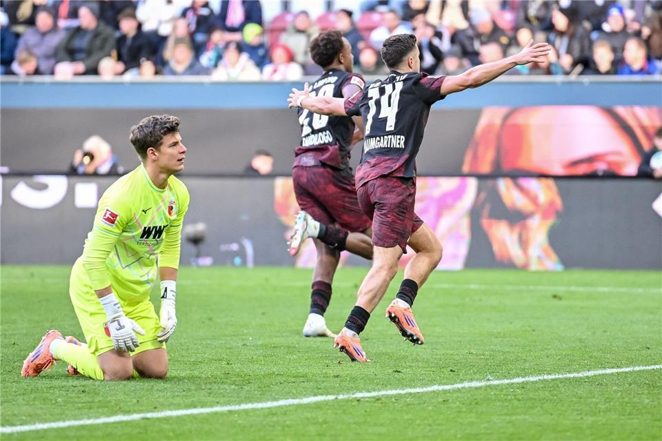 Junge Leipziger Turbo-Kicker führen naive Wagner-Elf vor  Augsburgs Torwart Finn Dahmen kauert bedröppelt am Boden, die Leipziger Assan Quedraogo (M) und Christoph Baumgartner (r) bejubeln das 0:5. Harry Langer/dpa