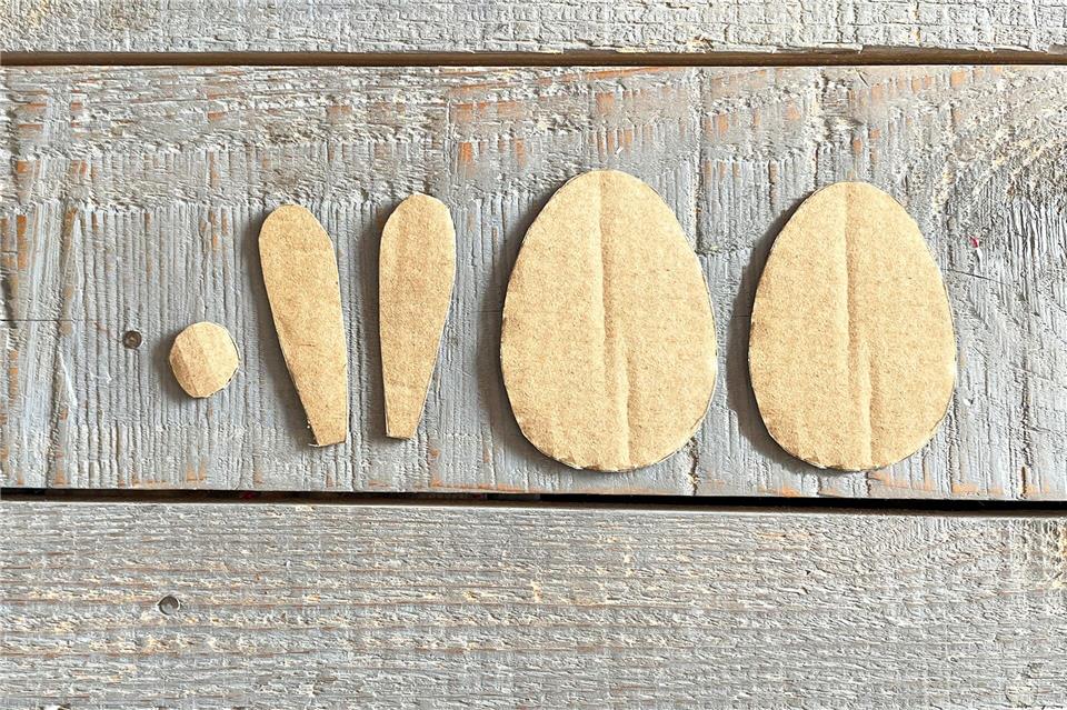 Aus dem Karton ein paar Hasenohren, einen kleinen Kreis sowie zwei Hasenkörper ausschneiden.DIY Academy/dpa-tmn