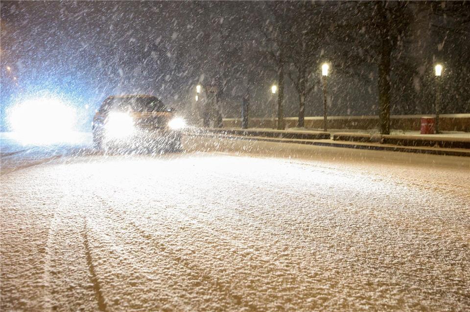 Autos fahren auf einer schneebedeckten Straße in Hamburg.Bodo Marks/dpa