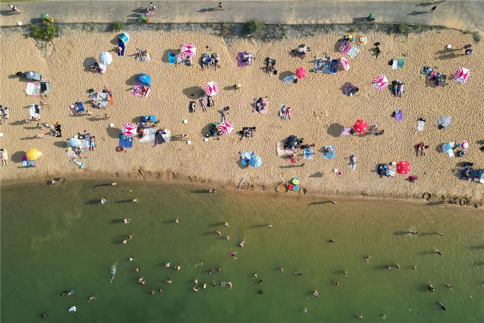 Badegäste liegen am Strand am Rather See in Köln (Luftaufnahmen mit einer Drohne).Sascha Thelen/dpa