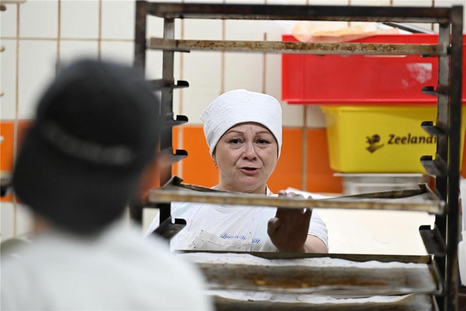 Bäckerin Liashenko spricht mit ihrem Kollegen in einer Backstube. Michael Brandt/dpa