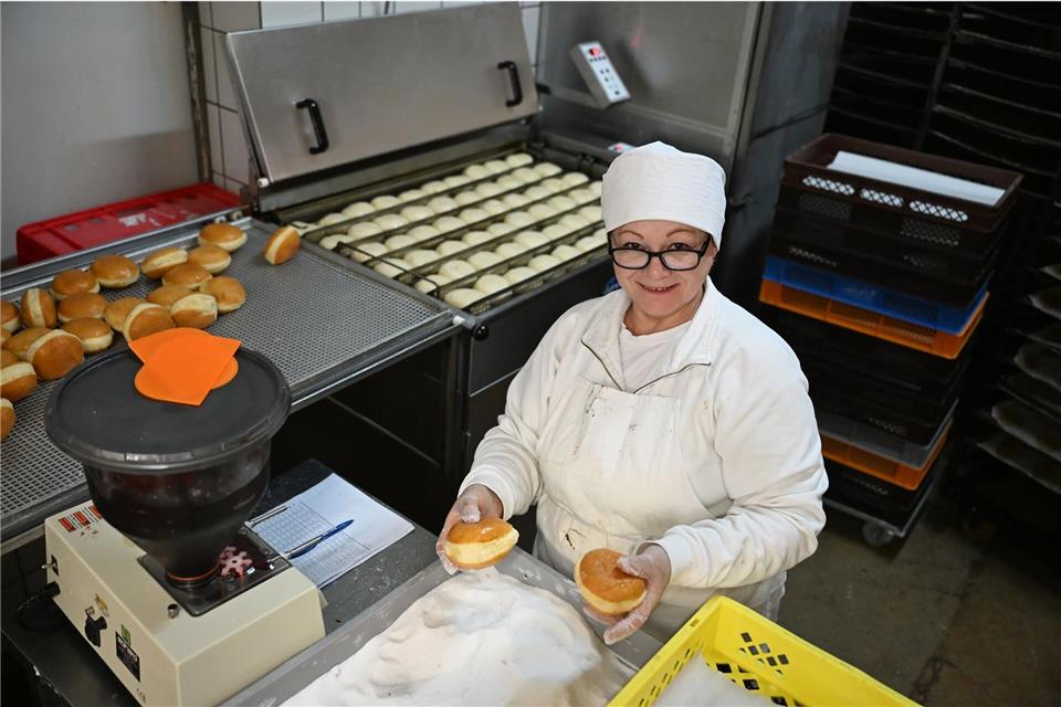 Bäckerin Svitlana Liashenko bepudert Berliner mit Zucker. Sie ist aus der Ukraine geflohen.Michael Brandt/dpa