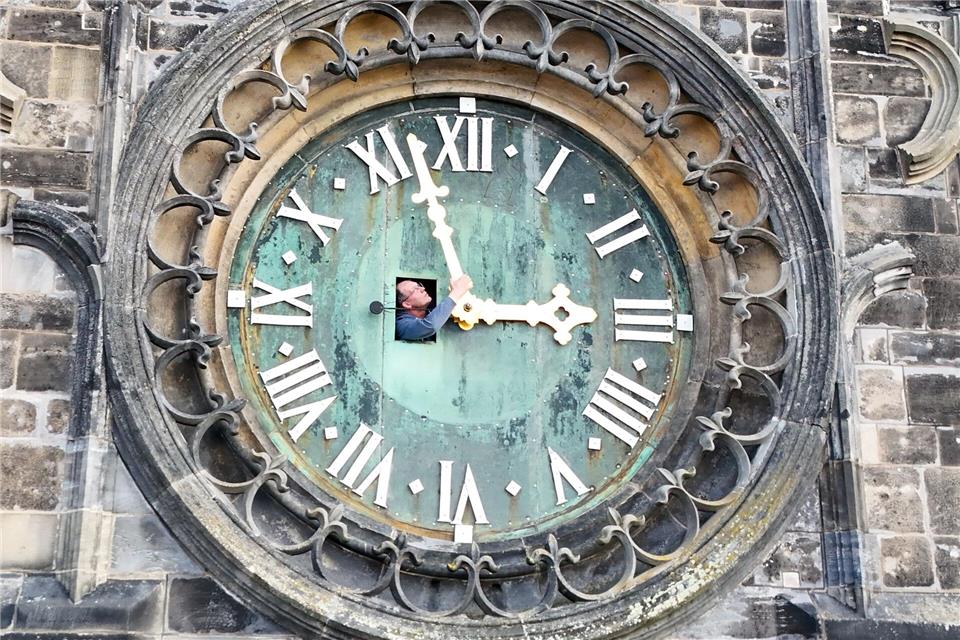 Bald kommt die Sommerzeit: Am Dom in Magdeburg werden die Zeiger der westlichen Turmuhr schon mal kontrolliert.Peter Gercke/dpa