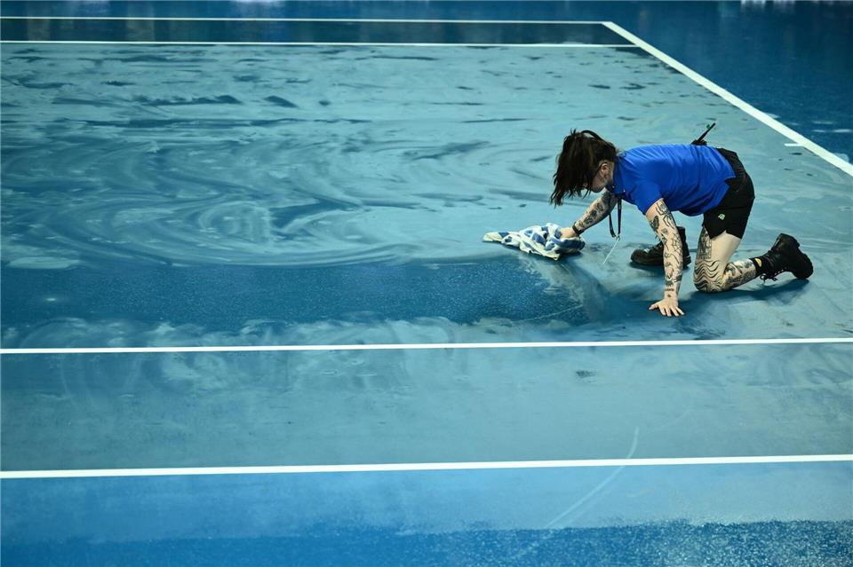 Ballkinder versuchten mit Handtüchern, die Plätze im Melbourne Park wieder zu trocknen.Joel Carrett/AAP/dpa