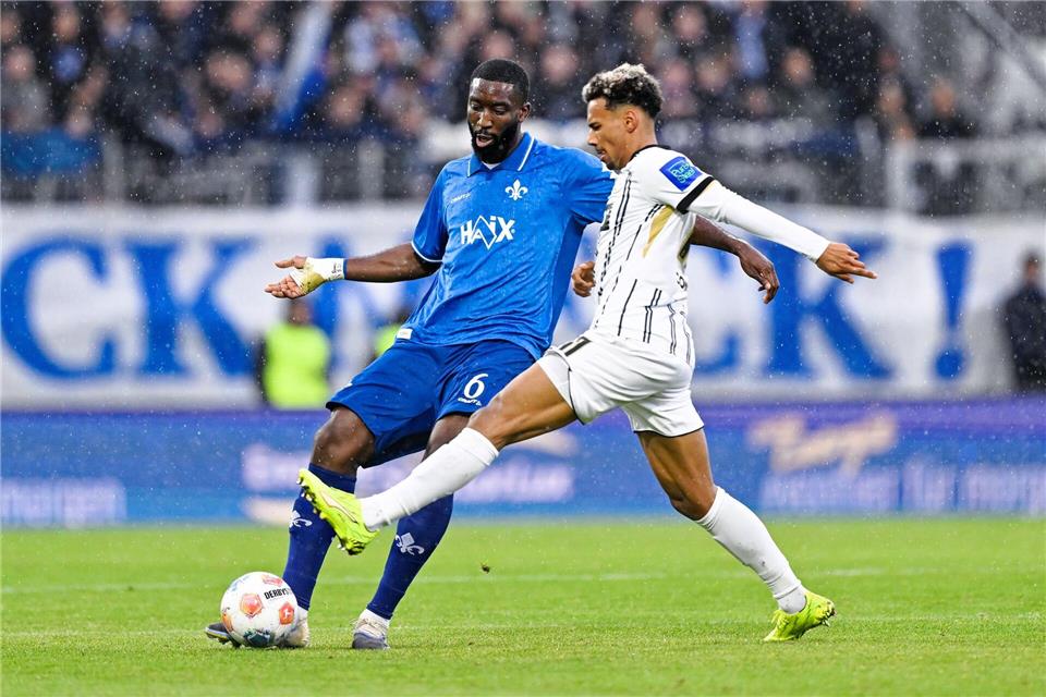 Bambasé Conté (r.) und die SV Elversberg bleiben gegen Darmstadt torlos. Uwe Anspach/dpa