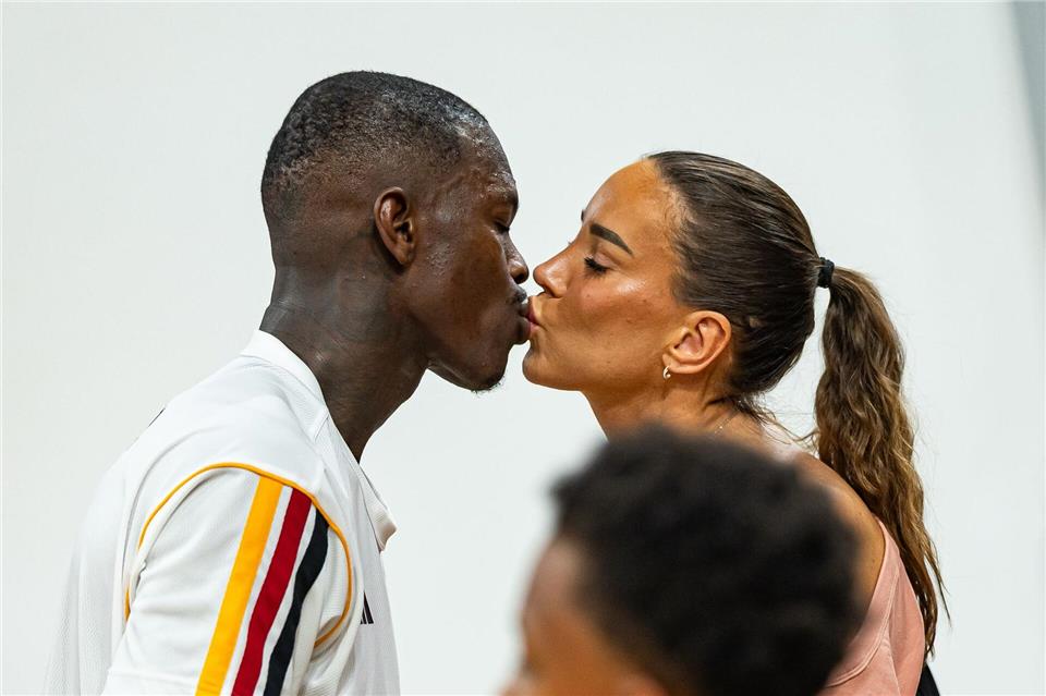 Basketball-Kapitän Dennis Schröder küsst seine Frau Ellen.Daniel Löb/dpa