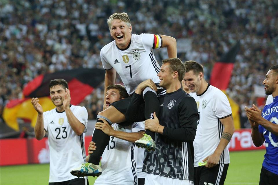 Bastian Schweinsteiger wird nach seinem letzten Länderspiel gegen Finnland von Thomas Müller (l) und Manuel Neuer (r) auf Schultern getragen. (Archivbild) picture alliance / dpa