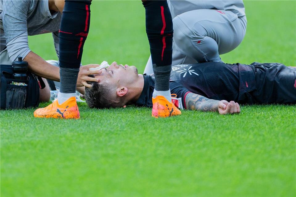 Bayer Leverkusens Kapitän Alejandro Grimaldo liegt nach einem Zusammenprall auf dem Boden. Rolf Vennenbernd/dpa