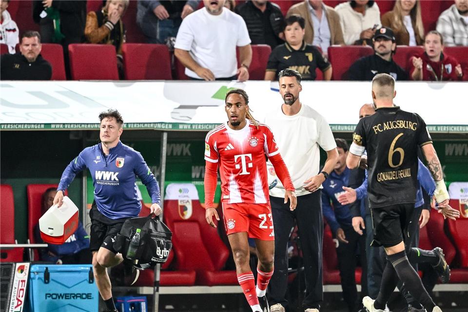 Bayern-Profi Sacha Boey (M.) sah für sein Foul an Augsburgs Robin Fellhauer Gelb.Harry Langer/dpa