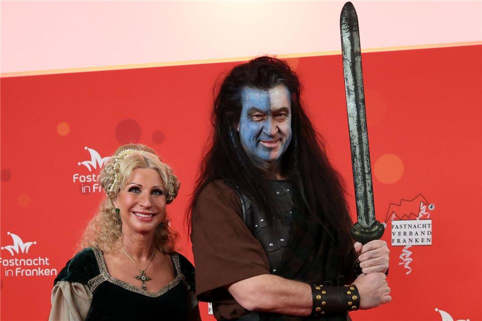 Bayerns Ministerpräsident Markus Söder und seine Frau Karin Baumüller-Söder zeigen sich vor Beginn der Prunksitzung „Fastnacht in Franken“ auf dem roten Teppich.Daniel Löb/dpa
