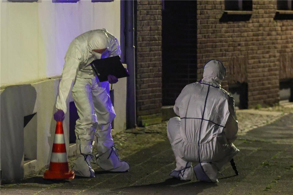 Beamte der Spurensicherung in Spurensicherungsanzügen begutachten den Tatort.Christoph Reichwein/dpa