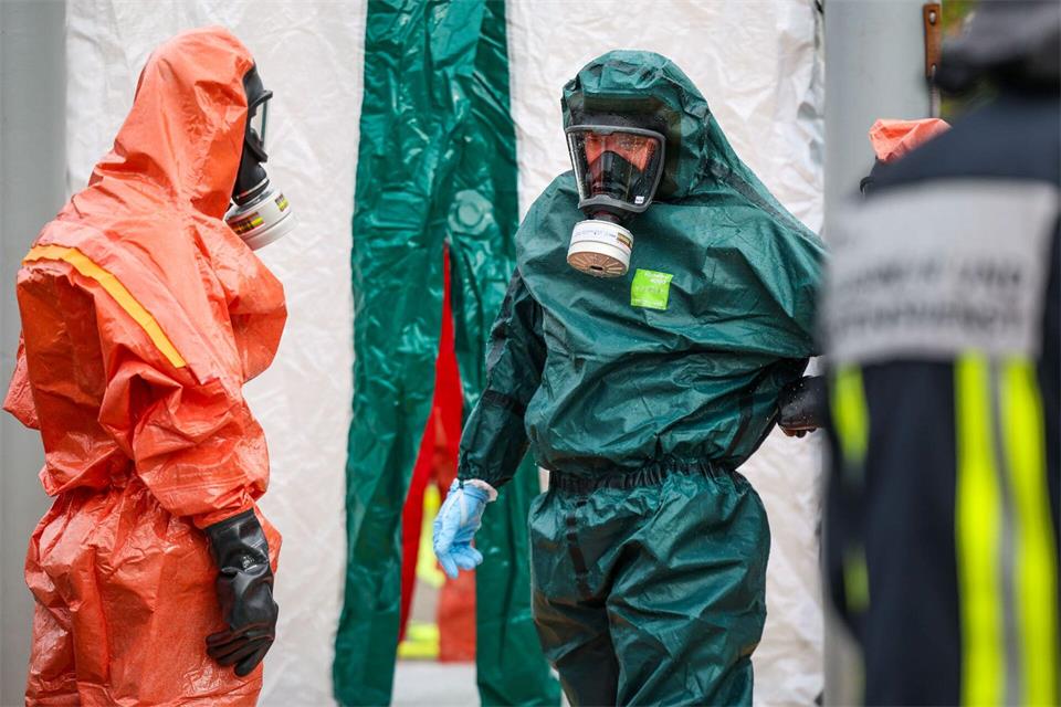 Beamte in Schutzanzügen nach der Explosion in Bochum. Möglicherweise wurden dort giftige Chemikalien gelagert. Christoph Reichwein/dpa