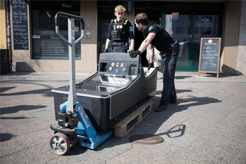 Beamte transportieren einen Spielautomaten aus einem Lokal. (Archivbild) Sebastian Gollnow/dpa