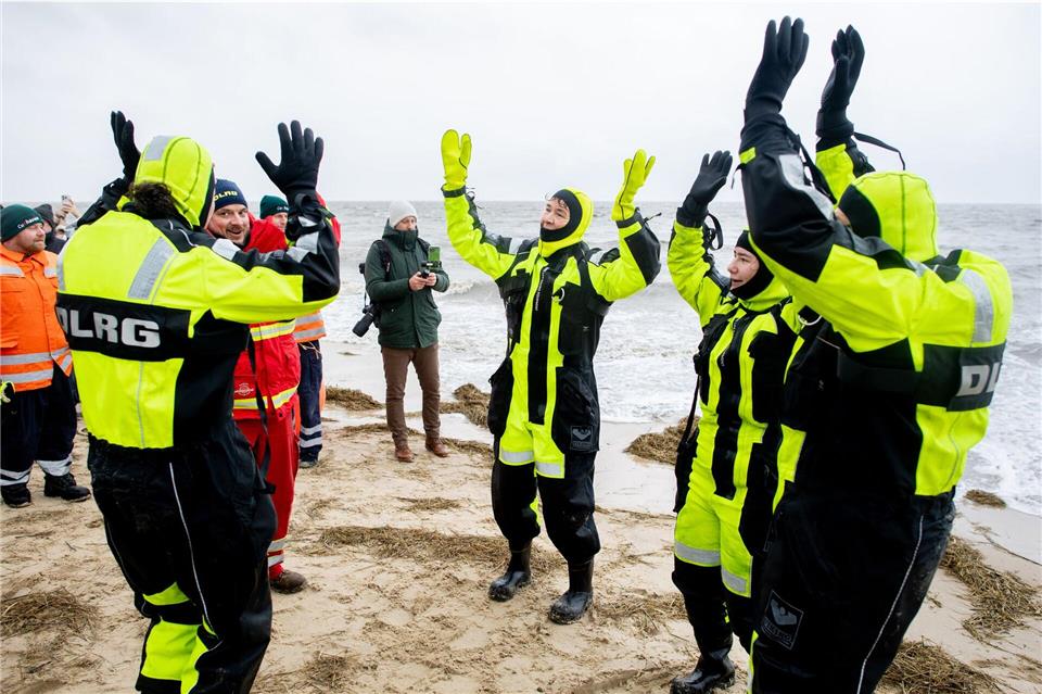 Begleitet vom DLRG feiern hunderte das Anbaden an Neujahr in Cuxhaven. Hauke-Christian Dittrich/dpa