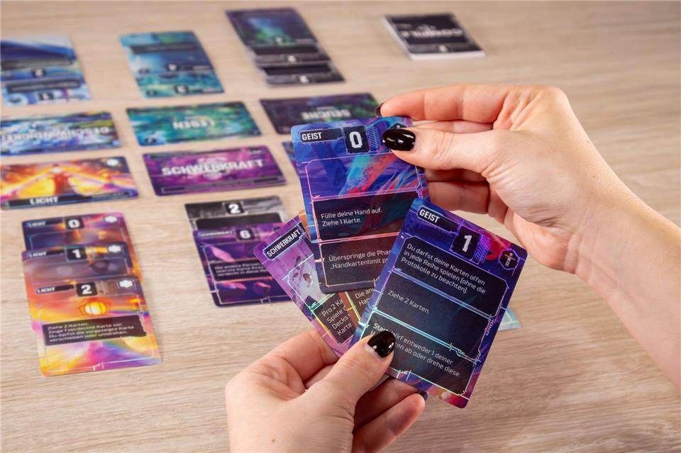 Bei „Compile“ wird entweder eine Karte ausgespielt oder ein Karten nachgezogen. Dabei geht es etwa um Themen wie Dunkelheit, Leben, Feuer oder Seuche.Pegasus Spiele/dpa-tmn