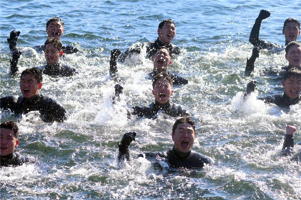 Bei Minusgraden singen Taucher der südkoreanischen Marine, während sie im eiskalten Meerwasser vor der Stadt Changwon schwimmen.yonhap/dpa
