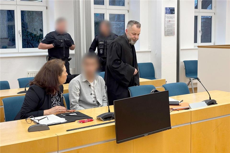 Bei Prozessbeginn äußerte sich der Beschuldigte (vorne, M) nicht zu den Vorwürfen. Der Mann mit türkischer Staatsbürgerschaft soll im Juni einen Behördenmitarbeiter vor der Gemeinschaftsunterkunft für Geflüchtete in Apolda mit einem Messer attackiert und dabei lebensgefährlich verletzt haben. Sebastian Münster/dpa