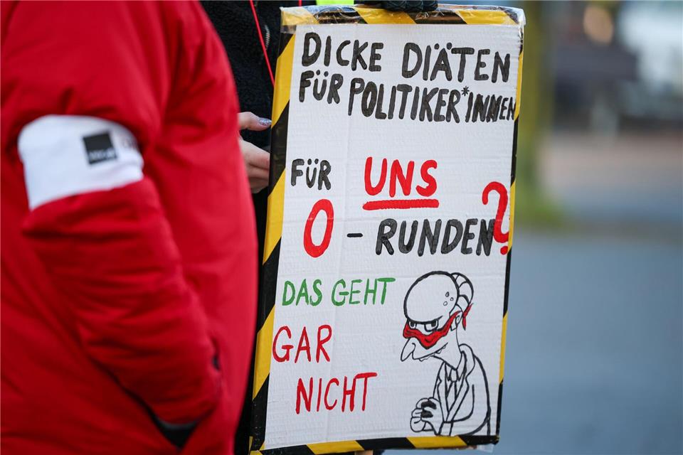 Bei der Auftaktkundgebung in Düsseldorf zeigen Teilnehmer Schilder zum Protest. Christoph Reichwein/dpa