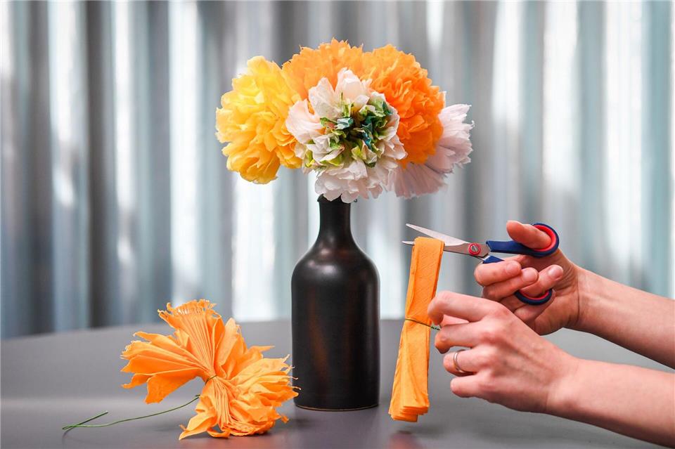 Bei dieser einfachen Variante entstehen üppige Blüten - dafür die gefaltete Serviette zurechtschneiden und dann die einzelnen Lagen auseinanderziehen!Zacharie Scheurer/dpa-tmn