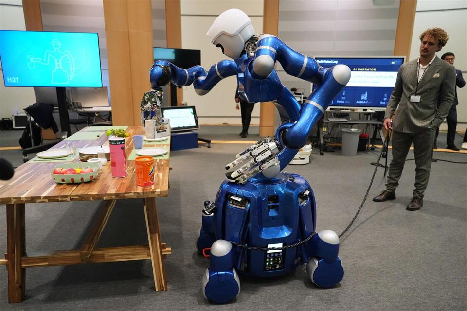 Bei einer Vorführung im Europäischen Parlament in Brüssel greift ein Roboter eine Packung Cracker.Virginia Mayo/AP/dpa