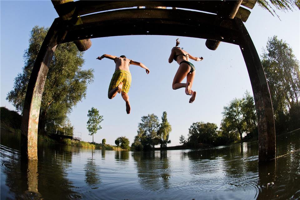 Beim Baden ist Vorsicht wichtig - hier springen zwei Menschen in einen See in Hannover. (Symbolbild)picture alliance / Julian Stratenschulte/dpa