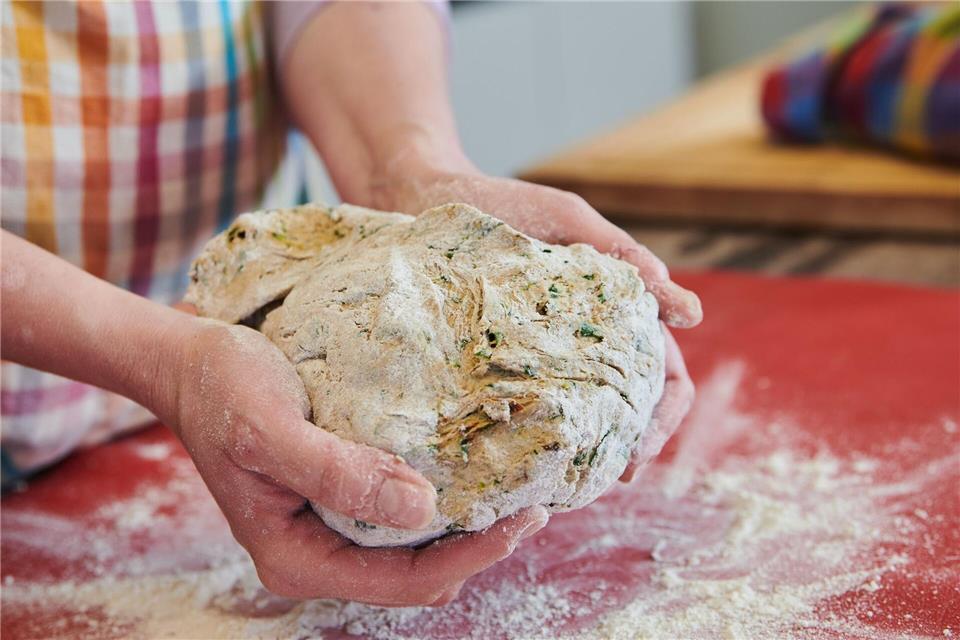 Beim „Gehen“ vergrößert Hefeteig sein Volumen. Damit die Luft raus kann, wird die Masse auf die Arbeitsfläche geschlagen. Das sogenannte „Abschlagen“ sorgt dafür, dass sich die Zutaten gut verbinden und der Teig geschmeidig wird. Annette Riedl/dpa/dpa-tmn