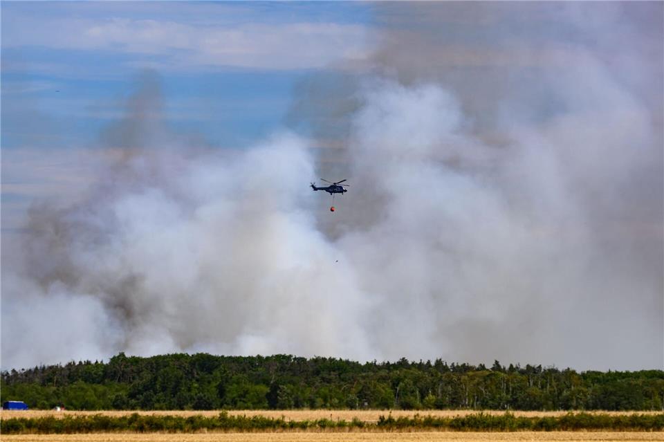 Feuerwehr ändert Taktik bei Waldbrand in der Gohrischheide Beim Kampf gegen die Flammen in der Gohrischheide kommen auch Löschhubschrauber zum Einsatz. Robert Michael/dpa
