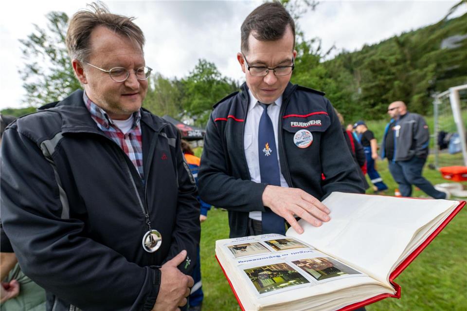 Beim Kreisjugendfeuerwehrtag wirft Robert Sesselmann einen Blick in die Chronik der Feuerwehr Neuhaus am Rennweg. Pia Bayer/dpa