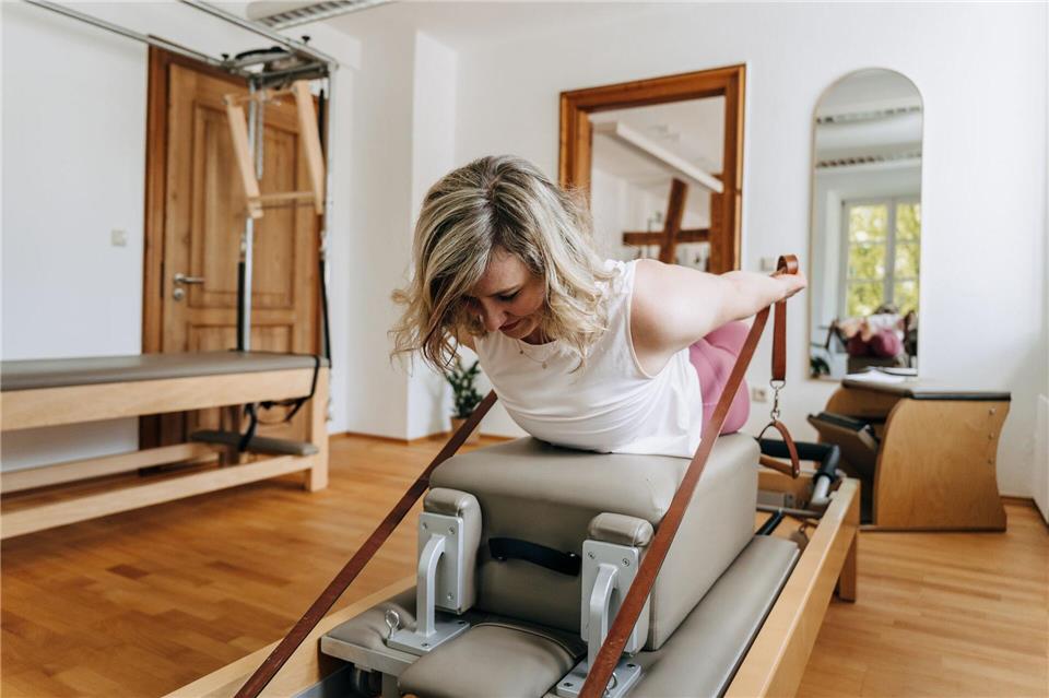 Beim Reformer-Pilates werden Übungen auf einem speziellen Gerät mit beweglicher Liegefläche, Federn und Seilzügen ausgeführt.Franziska Zeka/Echte Herzensmomente Fotografie/dpa-tmn