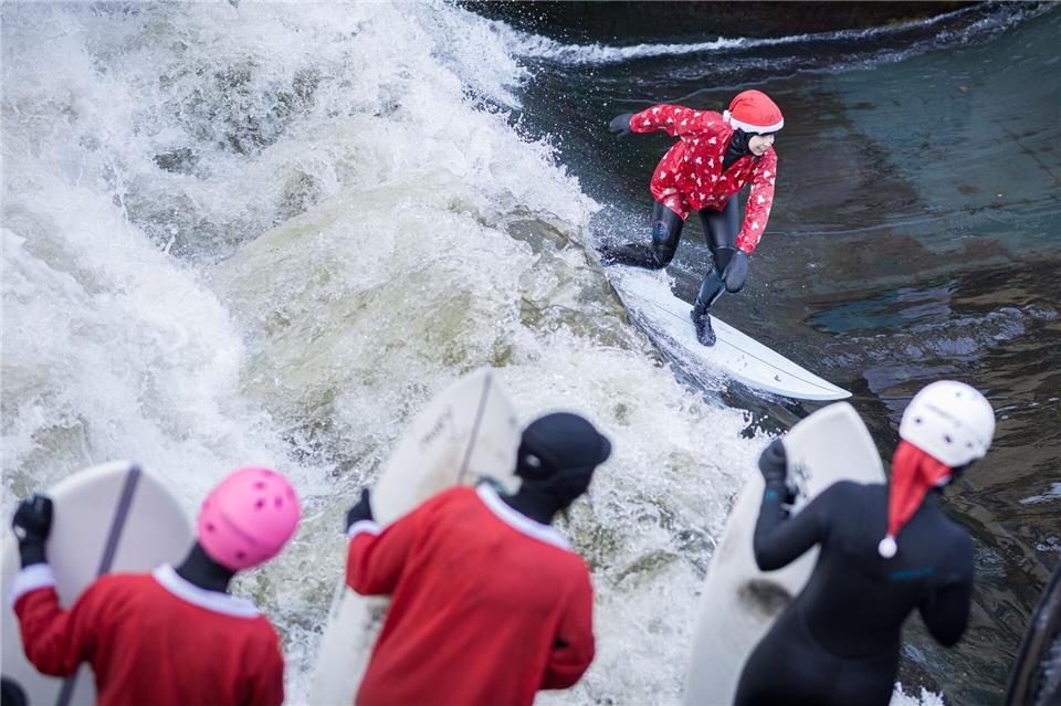 Beim „Santa Surf“ stürzen sich verkleidete Surfer in die eiskalte Leinewelle in Hannover.Moritz Frankenberg/dpa